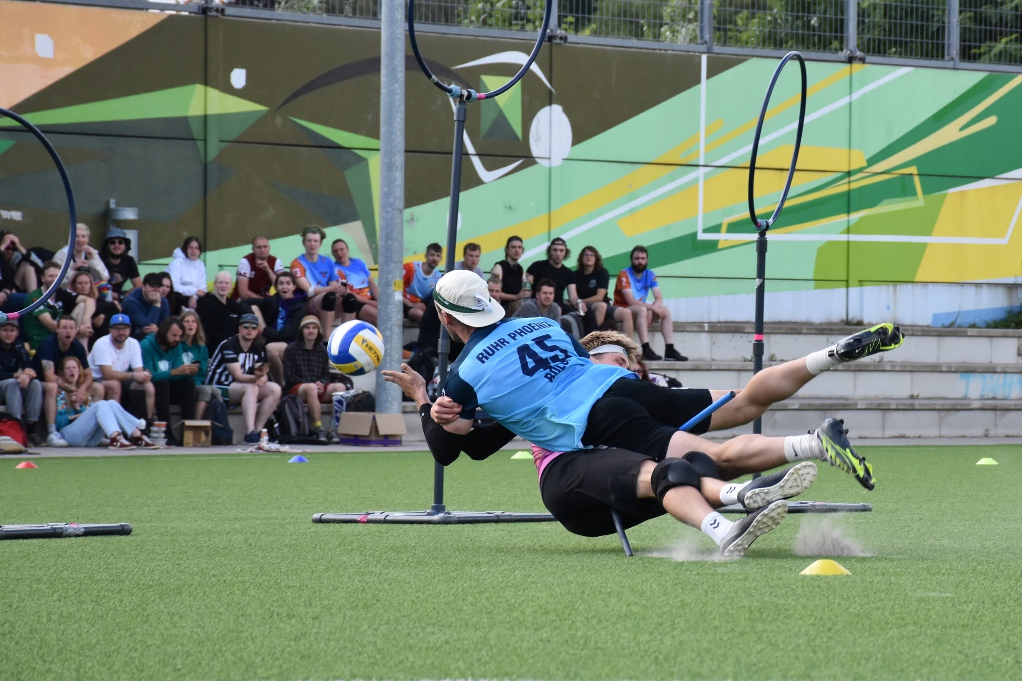 Training Ruhr Phoenix Spieler wirft Volleyball durch Ring, während er getackelt wird