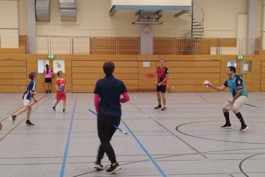 Kidditch Eine Gruppe von Kindern und Erwachsenen spielen zusammen Kidditch