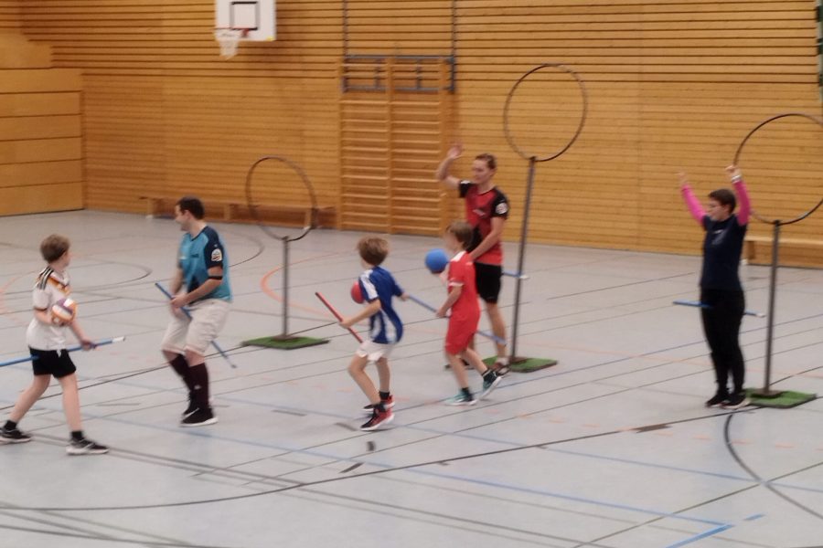 Kidditch Eine Gruppe von Kindern und Erwachsenen spielen zusammen Kidditch