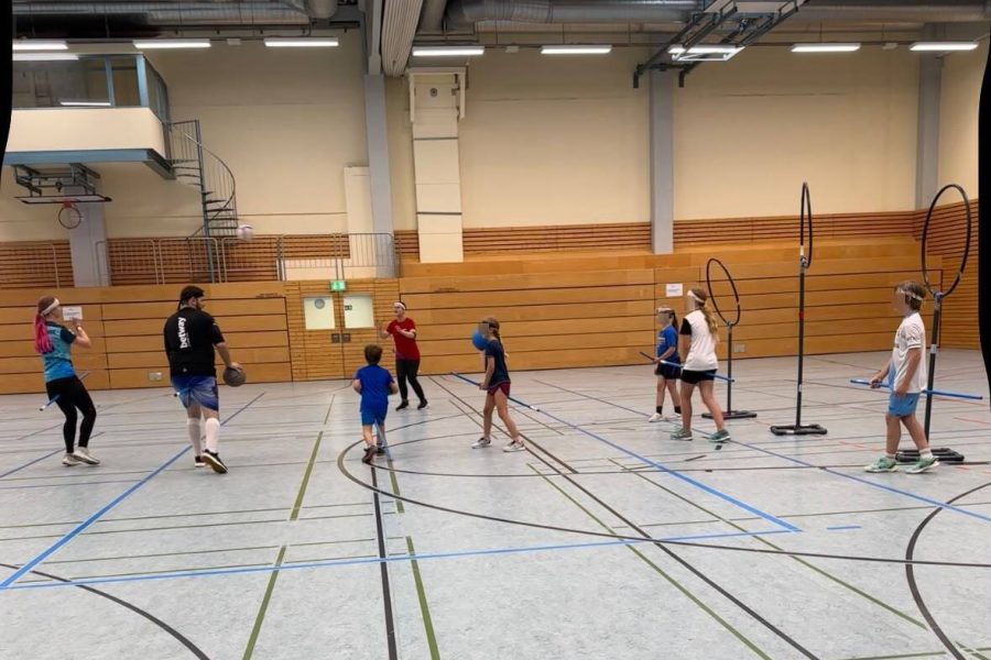 Kidditch Kinder und Erwachsene spielen gemeinsam Kidditch