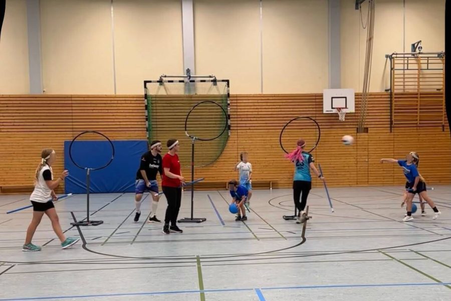 Kidditch Kinder und Erwachsene spielen gemeinsam Kidditch